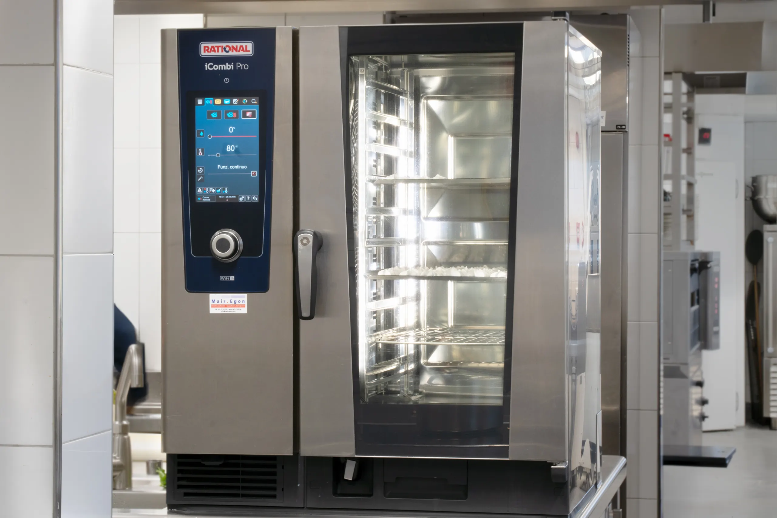 Ein Kombinationsofen der Marke Rational in einer Küche. Auf de linken Seite hat der Ofen einen Drehregler und einen Bildschirm.